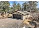 Detached garage with a dark metal door, stone accents, neutral siding, and an asphalt driveway at 21437 Alta Dr, Morrison, CO 80465