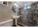 A full bathroom with dark stone tiling and an open walk-in shower at 1334 Xavier St, Denver, CO 80204