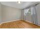 An empty bedroom featuring hardwood floors and a bright window adorned with patterned curtains at 1334 Xavier St, Denver, CO 80204