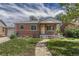 Charming brick home featuring a covered porch and well-maintained front yard with a walkway at 1334 Xavier St, Denver, CO 80204