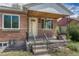 Close-up of the inviting brick porch and yellow front door with iron railings and stone accents at 1334 Xavier St, Denver, CO 80204