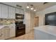 Well-lit kitchen featuring white cabinets, black appliances and tiled floor at 1334 Xavier St, Denver, CO 80204
