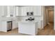 Modern kitchen featuring stainless steel appliances, wood floors, and white cabinets at 9673 Ceylon St, Commerce City, CO 80022