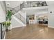 Open-concept living room with staircase, hardwood floors, and views into the dining area and kitchen at 3026 S Waco Ct, Aurora, CO 80013