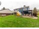 View of backyard with deck, patio, pergola, lush lawn, and garden beds at 10370 Routt St, Westminster, CO 80021
