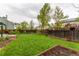 Spacious backyard with lawn, mature trees, and wood fence at 10370 Routt St, Westminster, CO 80021
