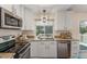 Bright kitchen features stainless steel appliances, white cabinets, and granite countertops at 10370 Routt St, Westminster, CO 80021