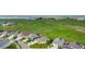 A high-angle view displays residences with solar panels backing onto green fields and distant water at 15779 W 83Rd Pl, Arvada, CO 80007