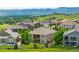 Aerial view of a backyard featuring a lush green lawn, deck, and mountain views at 15779 W 83Rd Pl, Arvada, CO 80007