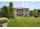 Beautifully landscaped backyard with mature trees, lush lawn, and a two story deck at 15779 W 83Rd Pl, Arvada, CO 80007