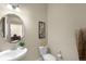 Cozy half bathroom with a stylish round mirror and decorative accents at 15779 W 83Rd Pl, Arvada, CO 80007