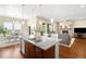 Open kitchen and dining area with a large island, stainless steel appliances, and hardwood floors at 15779 W 83Rd Pl, Arvada, CO 80007