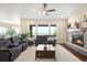 Open living room with fireplace, hardwood floors, ceiling fan, and outside view at 15779 W 83Rd Pl, Arvada, CO 80007
