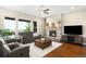 Bright living room featuring a stone fireplace, hardwood floors, and a flat-screen TV at 15779 W 83Rd Pl, Arvada, CO 80007