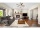 Spacious living room with fireplace, flat screen TV, ceiling fan, and hardwood floors at 15779 W 83Rd Pl, Arvada, CO 80007