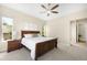 Spacious bedroom featuring a ceiling fan, a wooden bed frame, and natural light from the windows at 15779 W 83Rd Pl, Arvada, CO 80007