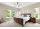 Spacious bedroom featuring a ceiling fan, a wooden bed frame, and natural light from the windows at 15779 W 83Rd Pl, Arvada, CO 80007