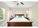 Spacious bedroom featuring a ceiling fan, a wooden bed frame, and natural light from the windows at 15779 W 83Rd Pl, Arvada, CO 80007
