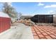 Backyard featuring a shed, landscaped areas, greenhouse and patio with stone accents at 4849 N Cook St, Denver, CO 80216