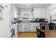 Charming kitchen featuring white cabinetry, black countertops, and stainless steel appliances at 4849 N Cook St, Denver, CO 80216