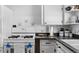 Close up of kitchen featuring white cabinets, countertops, sink, and appliances at 4849 N Cook St, Denver, CO 80216