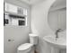 Bathroom features a pedestal sink, modern fixtures, and a window view at 2042 S Holly St # 3, Denver, CO 80222