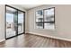 Bedroom with hardwood floors, large window, and access to balcony at 2042 S Holly St # 3, Denver, CO 80222