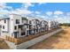 Row of modern townhouses featuring white siding, black trim, and stone accents at 2042 S Holly St # 3, Denver, CO 80222