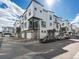 Modern townhomes with garage parking featuring white siding, black trim, and stone accents at 2042 S Holly St # 3, Denver, CO 80222