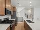 Contemporary kitchen boasts quartz countertops, stainless appliances, and a stylish staircase at 2042 S Holly St # 3, Denver, CO 80222