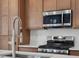 Kitchen features stainless steel appliances, wood cabinets, and a chrome faucet at 2042 S Holly St # 3, Denver, CO 80222