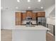 Modern kitchen featuring stainless steel appliances, a center island, and wood cabinets at 2042 S Holly St # 3, Denver, CO 80222