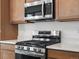 Kitchen features stainless steel appliances, wood cabinets, and quartz countertops at 2042 S Holly St # 3, Denver, CO 80222