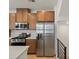 Modern kitchen features stainless steel appliances, wooden cabinets, and light countertops at 2042 S Holly St # 3, Denver, CO 80222