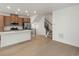 Open-concept living room features a modern kitchen, dining area, and a staircase, creating a spacious and inviting living space at 2042 S Holly St # 3, Denver, CO 80222