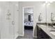 Bright bathroom featuring a glass enclosed shower and view into the adjacent bedroom at 1702 Metcalf Dr, Erie, CO 80516