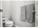 A clean and functional half bathroom featuring a toilet, toilet paper holder, and two hanging towels at 1702 Metcalf Dr, Erie, CO 80516
