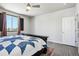 Comfortable bedroom featuring wood-look flooring, ceiling fan, and a large window with natural light at 1702 Metcalf Dr, Erie, CO 80516