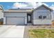 Charming single-Gathering home featuring solar panels, a gray facade, a well-kept lawn, and an attached garage at 1702 Metcalf Dr, Erie, CO 80516