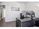 Bright home office featuring a modern desk and computer setup, with hardwood floors and soothing wall art at 1702 Metcalf Dr, Erie, CO 80516