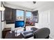 Bright home office featuring dual monitors, hardwood floors, and large windows with stylish dark shutters at 1702 Metcalf Dr, Erie, CO 80516