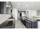 Well-equipped kitchen with stainless appliances, granite counters, a large island, and elegant wood-look flooring at 1702 Metcalf Dr, Erie, CO 80516