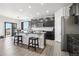 Kitchen with granite countertops, a large kitchen island, modern appliances, and stylish dark cabinets at 1702 Metcalf Dr, Erie, CO 80516
