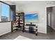 Living room featuring a TV, entertainment center, modern grey hardwood floors, a bookcase and a sunlit window at 1702 Metcalf Dr, Erie, CO 80516