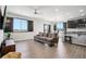 Open-concept living area with dark wood floors, sleek black window shutters, and an airy ambiance at 1702 Metcalf Dr, Erie, CO 80516