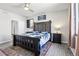 Main bedroom features rustic wood bedframe, ceiling fan, rug and bedside tables with lamps at 1702 Metcalf Dr, Erie, CO 80516