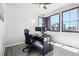 Bright office features sleek wood floors, large black windows, and a stylish black executive desk with a modern computer setup at 1702 Metcalf Dr, Erie, CO 80516