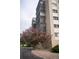 Exterior shot shows blooming trees, building facade and architectural details around ground level garage entrances at 14091 E Marina Dr # 612, Aurora, CO 80014