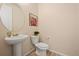 Small bathroom with pedestal sink, toilet, and decorative artwork at 39260 Braxton Ln, Elizabeth, CO 80107