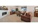 Living room with a fireplace, brown couches, and a large TV at 39260 Braxton Ln, Elizabeth, CO 80107